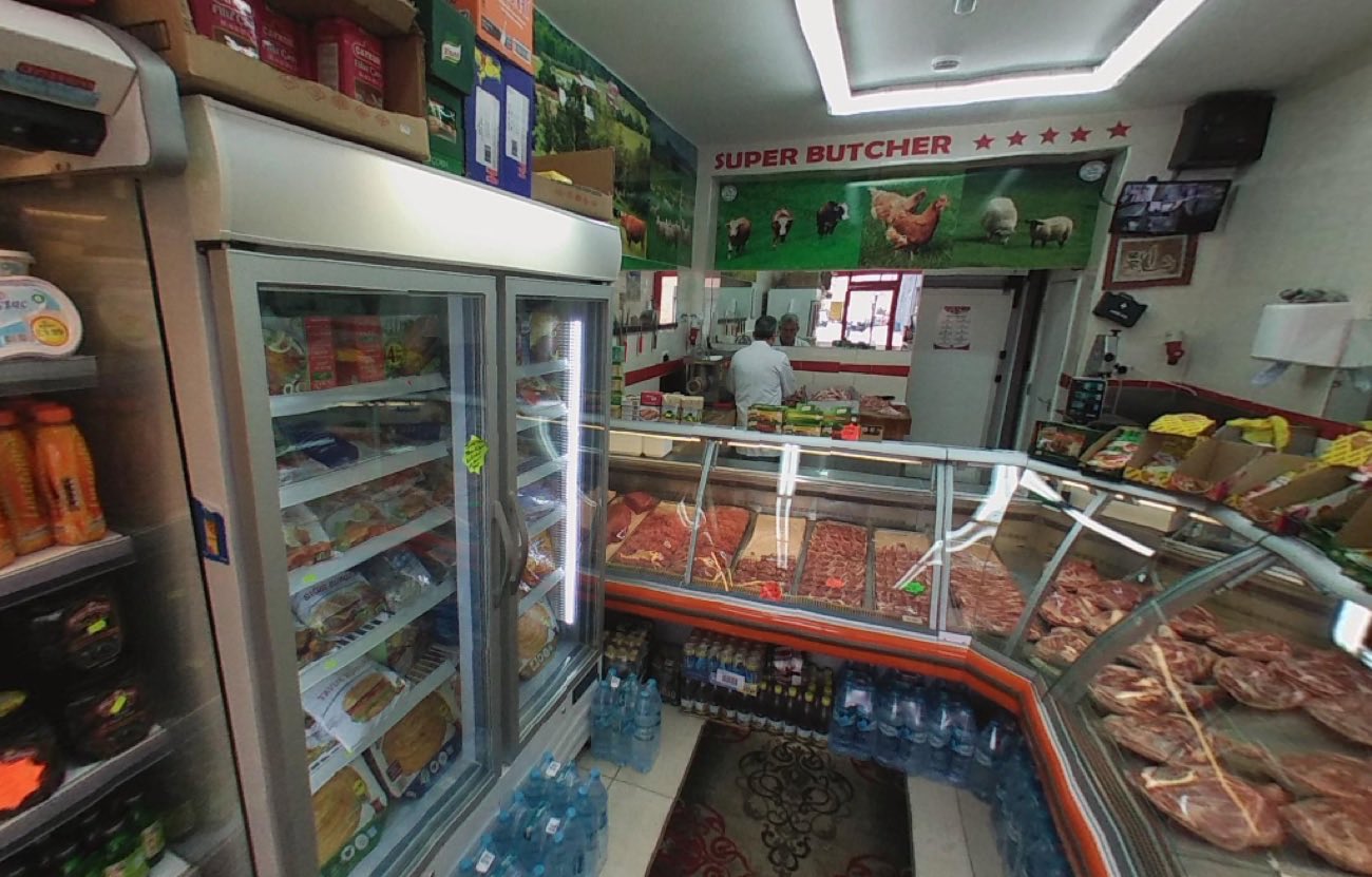The meat counter at Super Butcher Hackney, with the day's cuts laid out in the display case and a butcher working behind it.