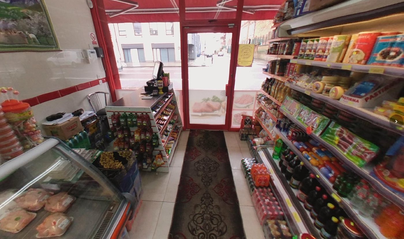 Inside Super Butcher looking toward the door and Stoke Newington Road, with the counter on the left and grocery shelves on the right.